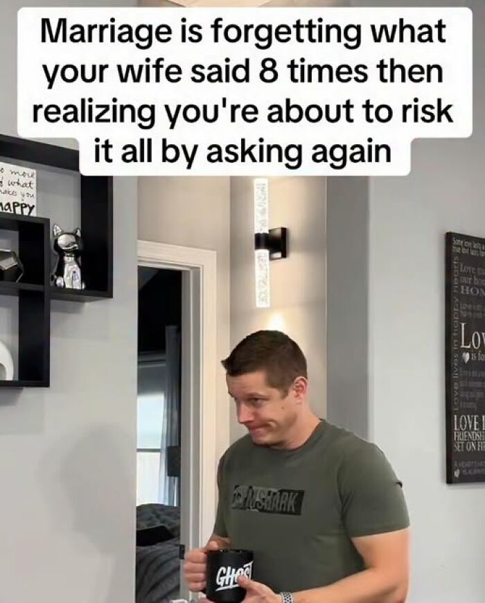 Man holding a coffee mug with a humorous marriage meme about forgetting what your wife said multiple times.