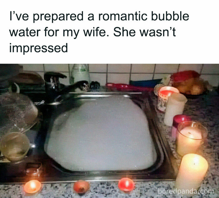 Romantic bubble water prepared in sink with lit candles around, reflecting funny and chaotic marriage memes humor.