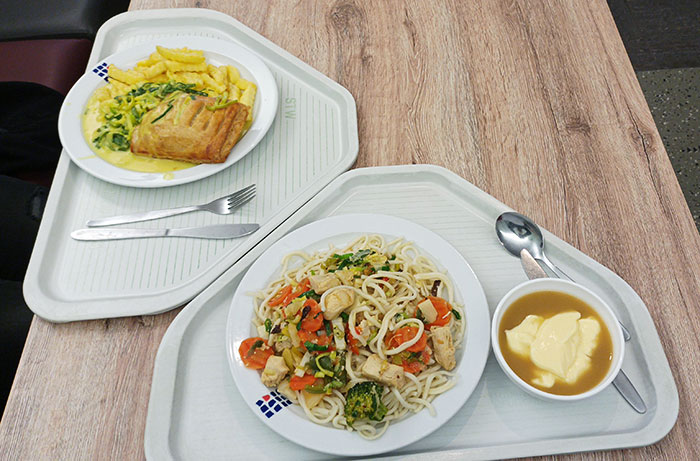 Two meals on uniquely shaped trays designed to fit together, showcasing real-world genius design ideas in dining.