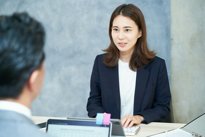 Young woman in a business suit attending a job interview discussing potential red flags in a toxic workplace environment