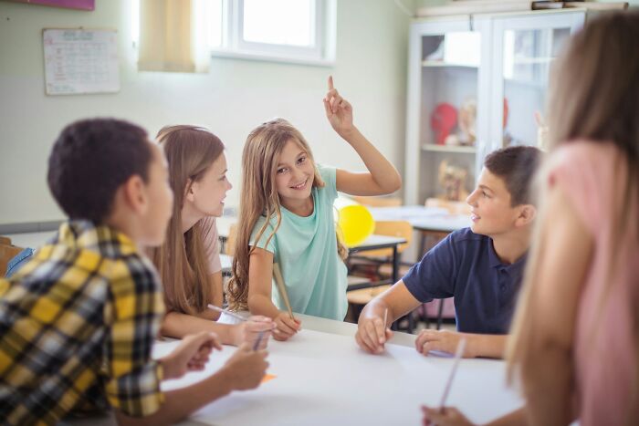 Group of children happily engaged in classroom activity, highlighting positive moments and bits of good news.