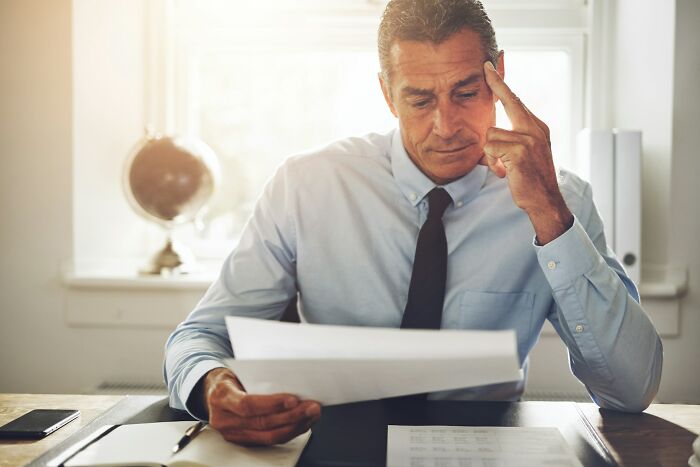 Man in business attire reviewing documents at desk, contemplating job interview red flags indicating toxic workplace risks
