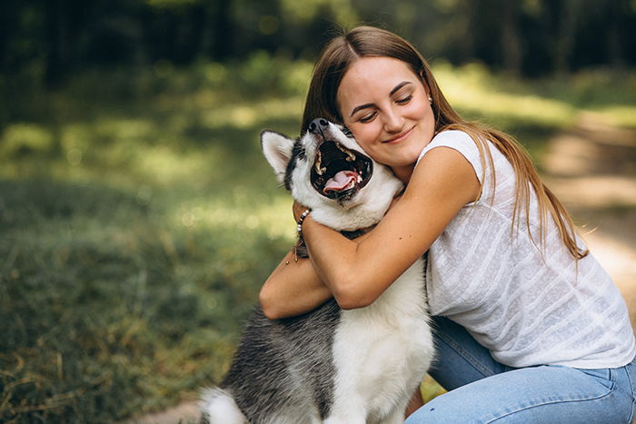 Young woman hugging a husky outdoors, showing affection and playful interaction with the loyal dog. - 36