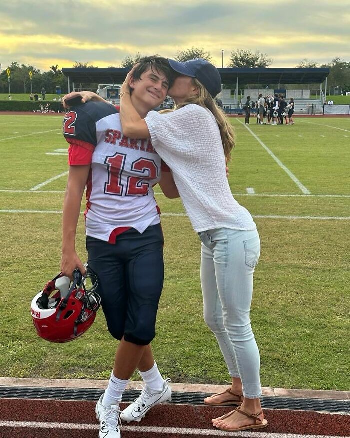 Gisele B&uuml;ndchen with her son on a football field showing a tender moment amid parenting tensions with Tom Brady.