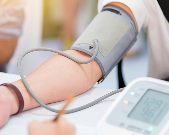 Arm with blood pressure cuff measuring health of gymgoer after post-workout mistake, expert shares prevention tips.