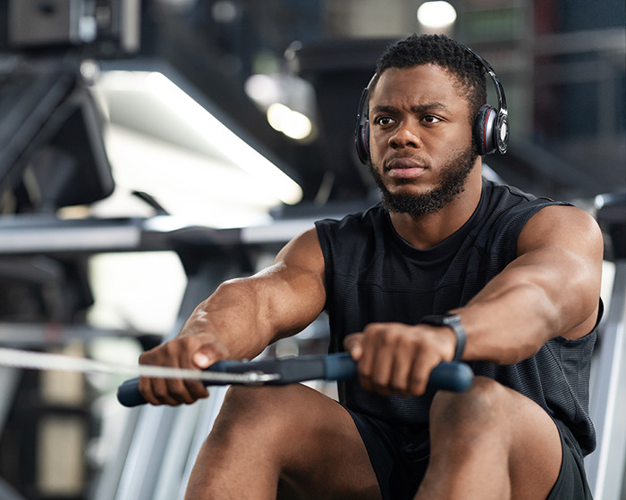 Gymgoer focused during rowing exercise at gym, highlighting risks of common post-workout mistakes and expert prevention tips.