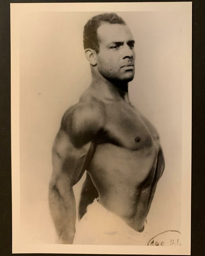 Muscular Victorian man posing shirtless, showcasing strength and handsome features in a vintage black and white photo.