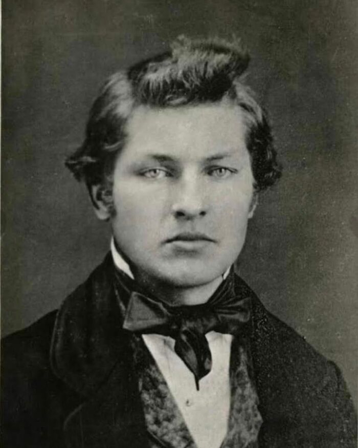 Victorian man in formal attire with bow tie, representing handsome Victorian men from historical portraits.