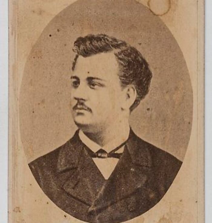Vintage portrait of a handsome Victorian man with styled hair and mustache wearing a dark suit jacket and bow tie.