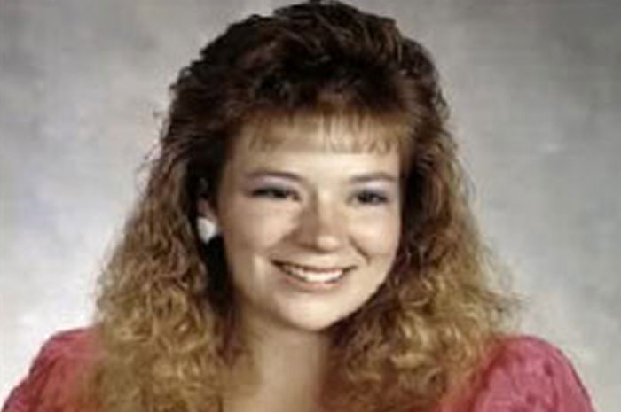 Young woman with curly hair smiling in a portrait photo, representing chilling messages left before going missing cases.