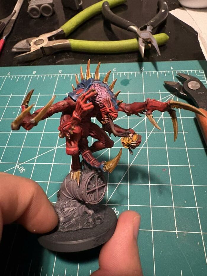 Hand-painted detailed mini creature on a crafting mat with tools, perfect for any man excited to see these pics.