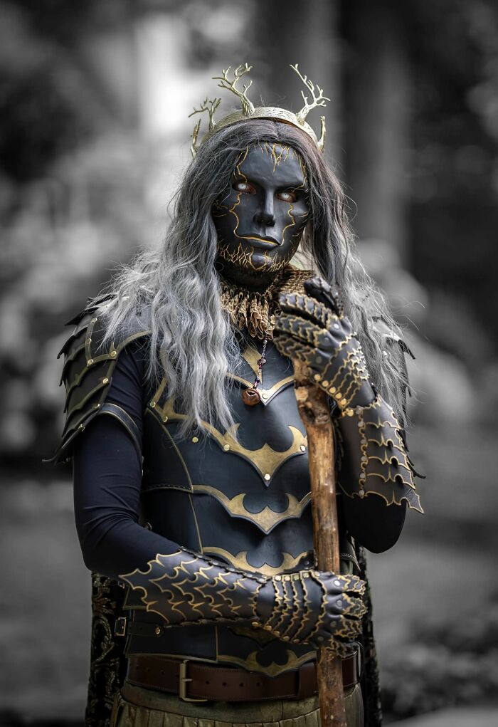 Man in detailed dark fantasy armor and mask holding a wooden staff, embodying themes that any man would be excited to see