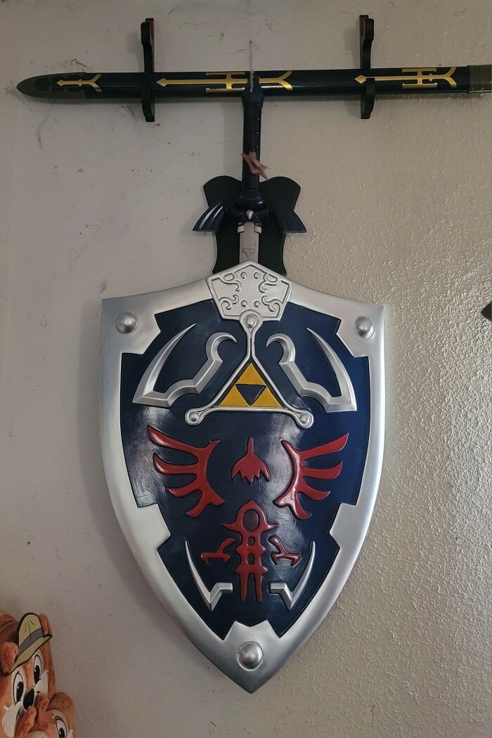 Hylian shield and sword mounted on wall, a detail any man would be excited to see from gaming memorabilia.
