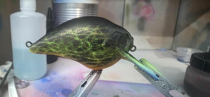Close-up of a detailed fishing lure being painted, showcasing craftsmanship that any man would be excited to see.
