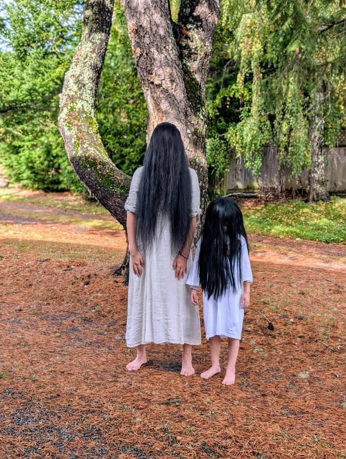 Two people with long black hair covering their faces stand barefoot outdoors, a striking image from any man excited pics thread.
