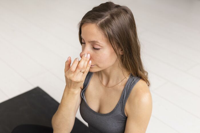 Teen girl practicing breathing exercise indoors, illustrating calm and focus amid snooping parents discovering new teen behaviors. - 19