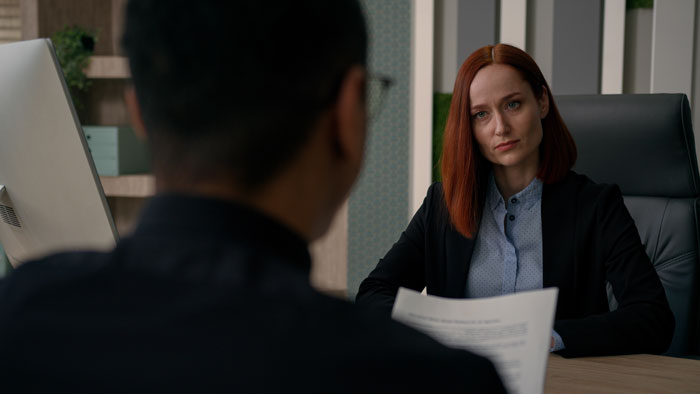 HR manager listening seriously to an employee in an office, addressing toxic behavior and workplace conflicts.