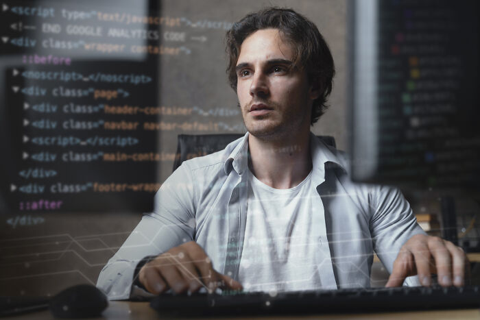Man focused on coding and typing at computer, representing hiring managers dealing with difficult people situations.
