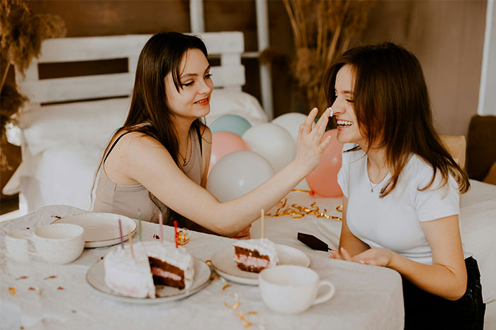 Two women celebrating a birthday with cake and balloons, highlighting a husband’s birthday surprise leading to therapy. - 33