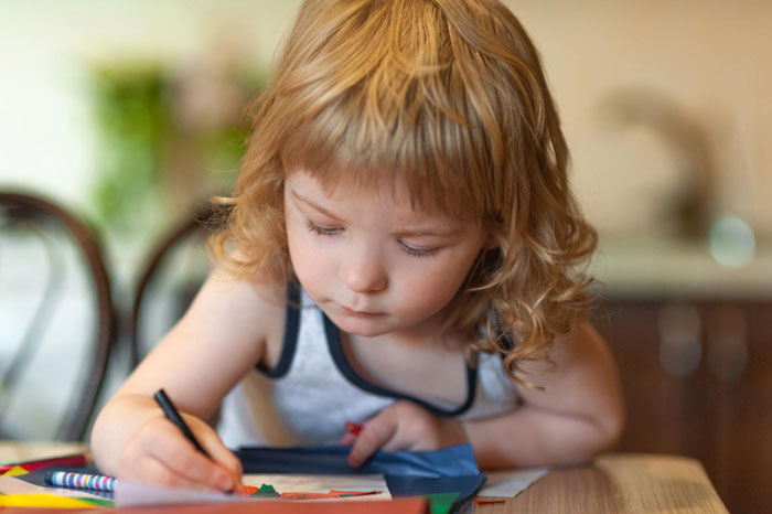 Toddler drawing indoors while husband left baby on mown lawn, focusing on quiet play at a wooden table. Toddler drawing indoors while husband left baby on mown lawn, focusing on quiet play at a wooden table.