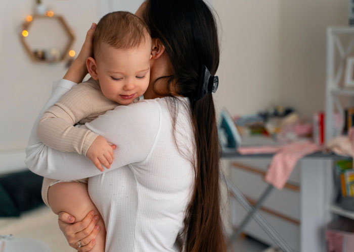 Woman holding baby indoors while husband left baby unattended after mowing lawn in a cozy home setting. Woman holding baby indoors while husband left baby unattended after mowing lawn in a cozy home setting.