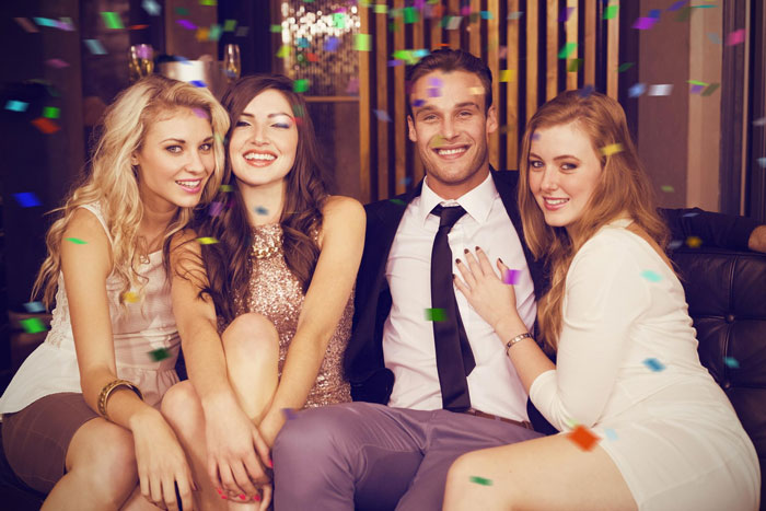 Group of young adults celebrating indoors with confetti, capturing a moment related to wife surprise visitor and pregnancy claim. - 1
