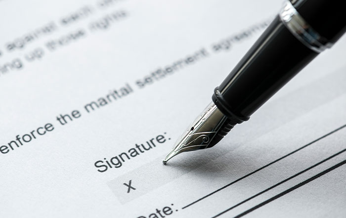 Close-up of a fountain pen poised to sign a divorce document highlighting man demands divorce from wife. Close-up of a fountain pen poised to sign a divorce document highlighting man demands divorce from wife.