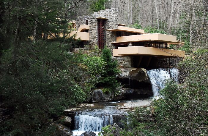 Iconic architectural homes featuring a modern house built over a waterfall surrounded by lush forest greenery.