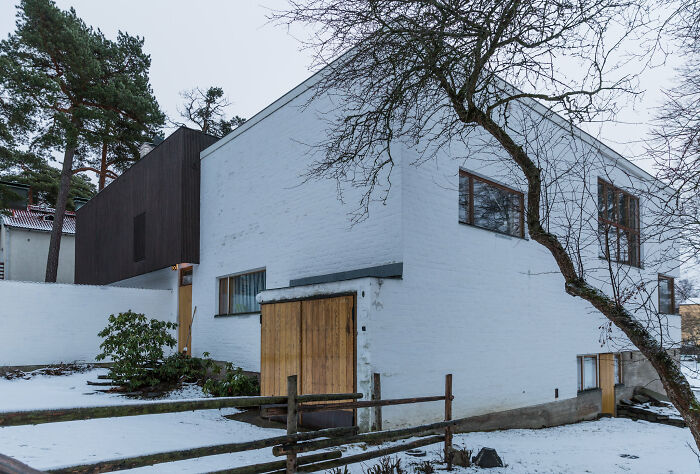 Modern iconic architectural homes with white walls, wooden accents, large windows, and surrounding snowy landscape.