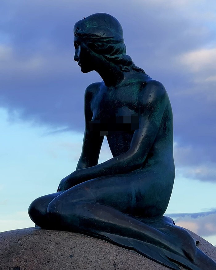Bronze famous mermaid statue sitting on a rock with a cloudy sky background, subject of controversy and planned demolition. - 9