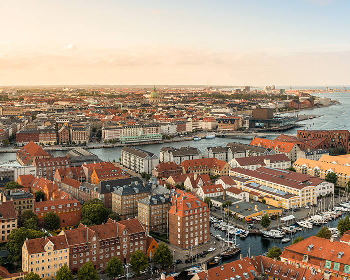 Aerial view of a coastal city with boats docked at the marina near a famous mermaid statue location. - 1