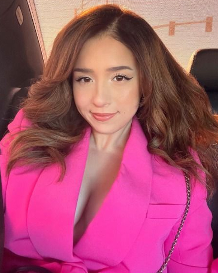 Young woman in a bright pink outfit showcasing a classic celebrity wardrobe malfunction style in a car selfie.