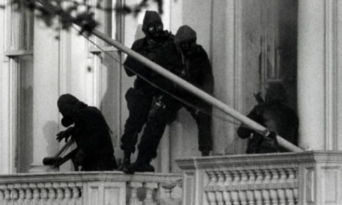 Black and white photo showing armed masked men scaling a building in a weird history moment captured in the past.