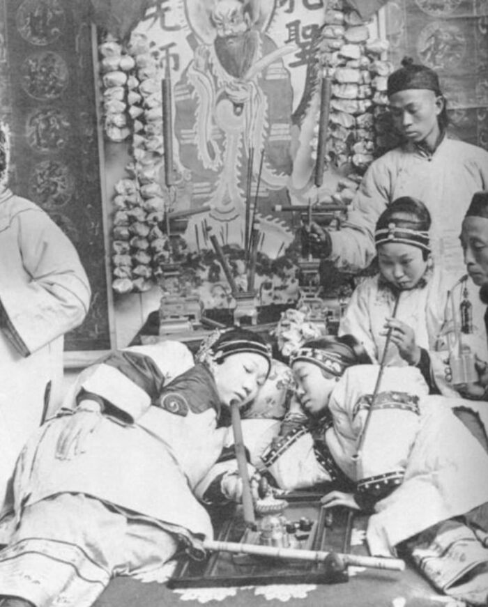 Traditional East Asian group smoking pipes in a historic setting, showcasing weird history pics from the past.