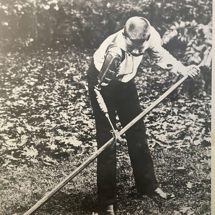Boy with early prosthetic arm working outside, a weird history pic showing past adaptive technology and daily life.