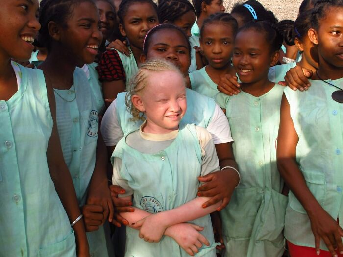 A group of schoolchildren smiling and interacting, showcasing everyday life in a vibrant street photo.