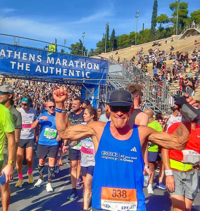 Runner celebrating at the Athens Marathon finish line, showcasing strength and endurance, proof that superhumans walk among us.