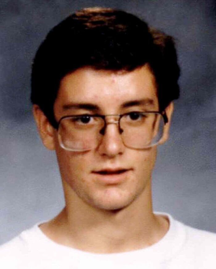 Young man with glasses and dark hair in a school photo representing chilling disappearances from the '90s.