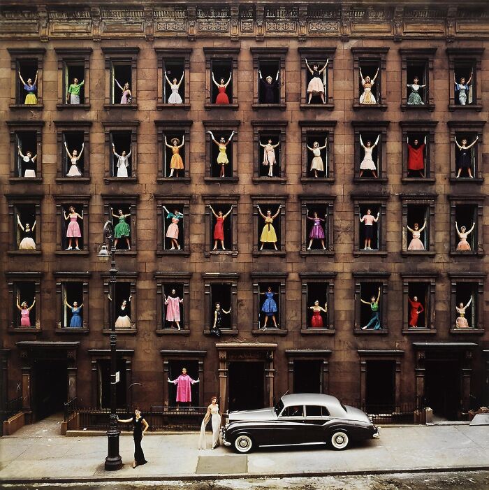 Women in colorful dresses pose in open windows of a brick building, capturing iconic moments in history.