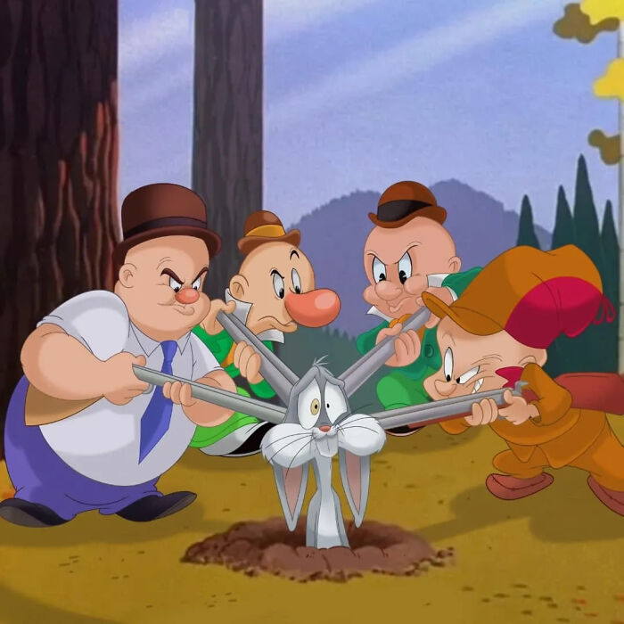 Looney Tunes characters Elmer Fudd and Yosemite Sam surrounding Bugs Bunny in a cartoon mashup scene outdoors.