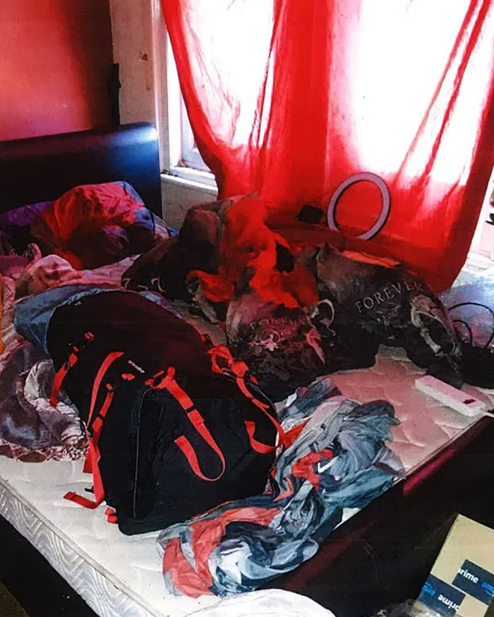 Cluttered bedroom with red curtains, bags, and clothes scattered on a bed, highlighting crucial signs ignored in vegan diet case.