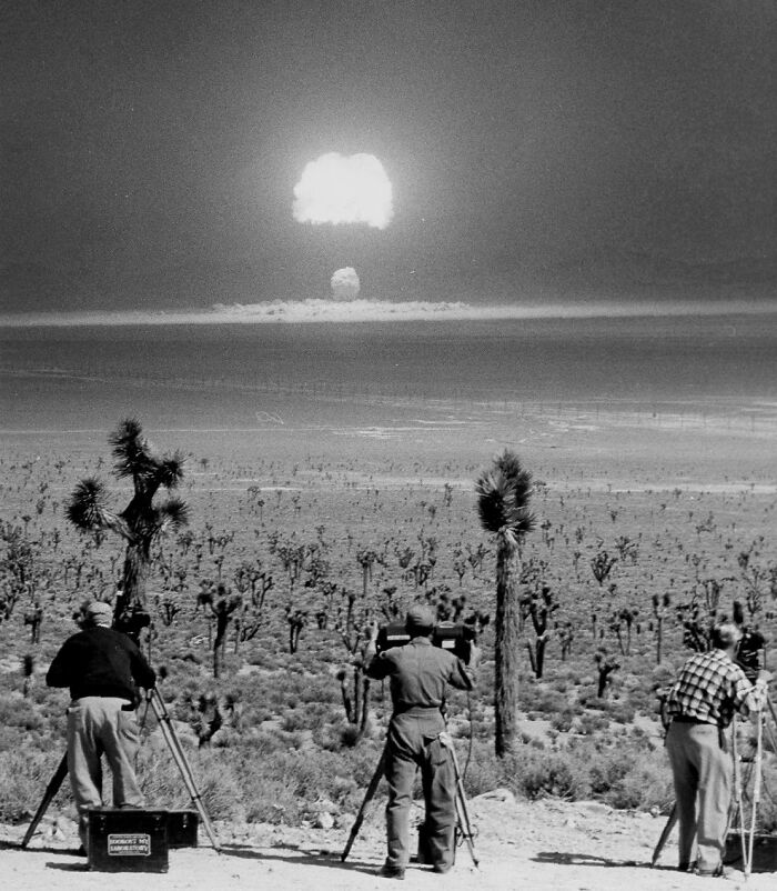 Historians capturing footage of a nuclear explosion in a desert landscape revealing unfamiliar parts of history.