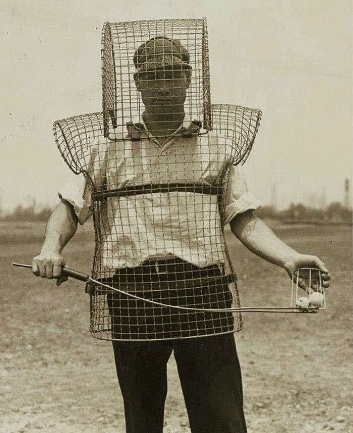 Man wearing early 20th century protective gear during sports practice, showing unfamiliar parts of history in equipment design.