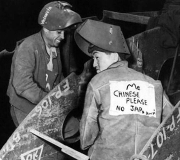 Two welders in protective gear working together, highlighting unfamiliar parts of history through a candid black and white photo.