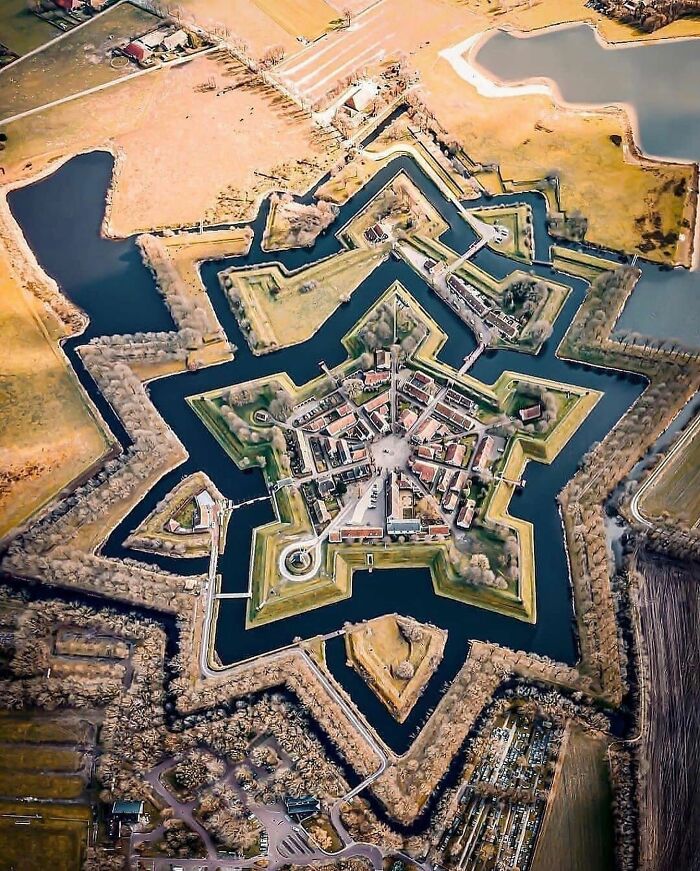 Aerial view of a star-shaped fortress surrounded by water showcasing unfamiliar parts of history and architecture.