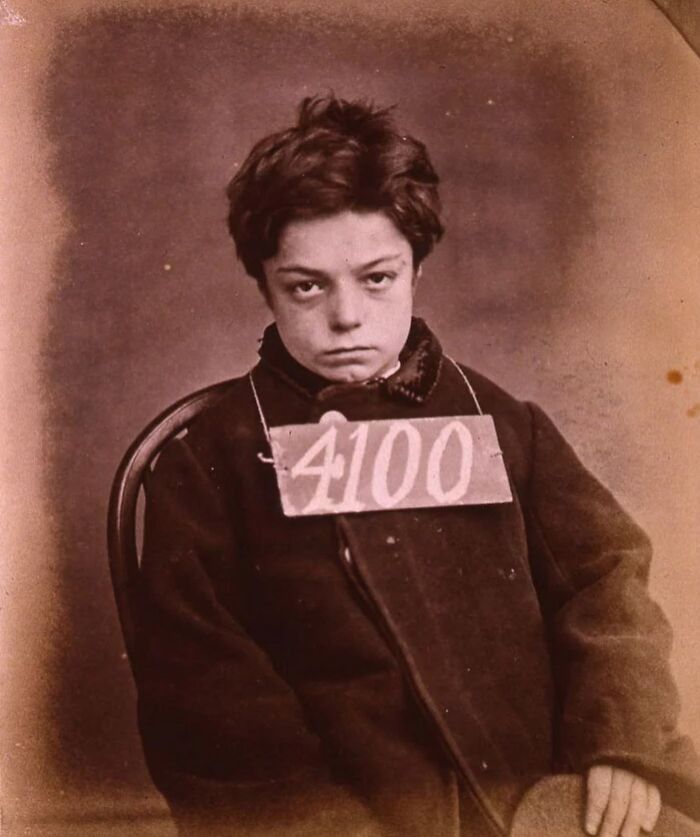 Young boy with a prison number tag in a vintage photo revealing unfamiliar parts of history.
