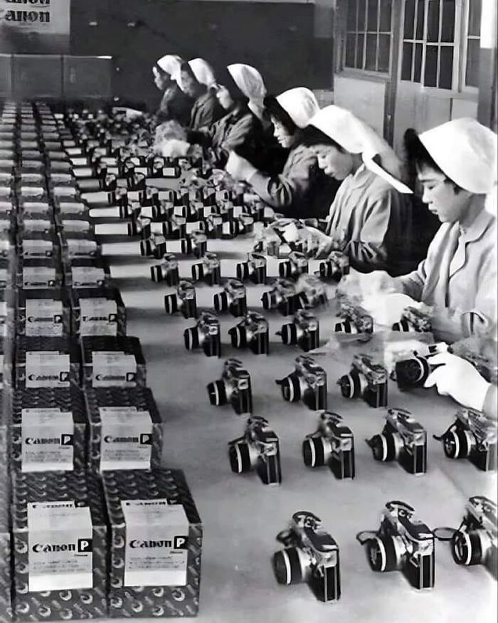 Women assembling Canon cameras in a factory, showcasing unfamiliar parts of history in early camera manufacturing.