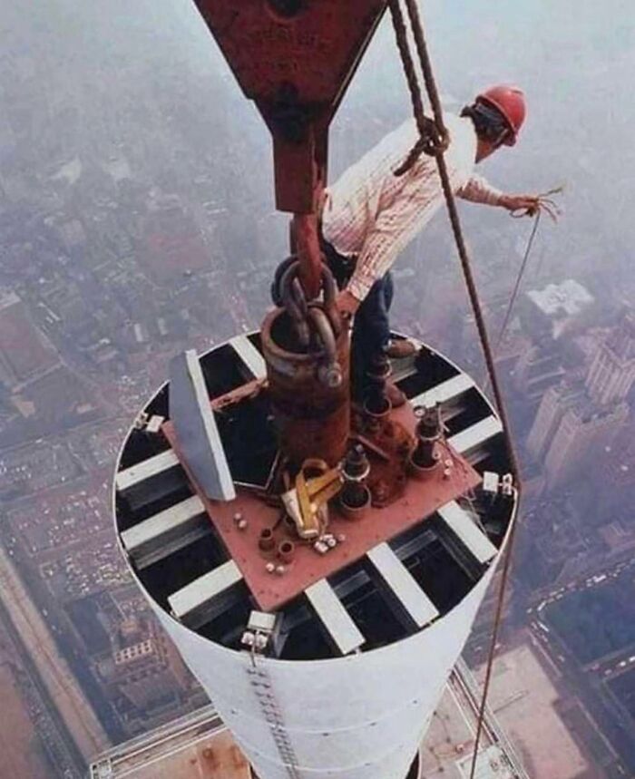 Construction worker standing on a high steel structure, showing unfamiliar parts of history in daring industrial work.