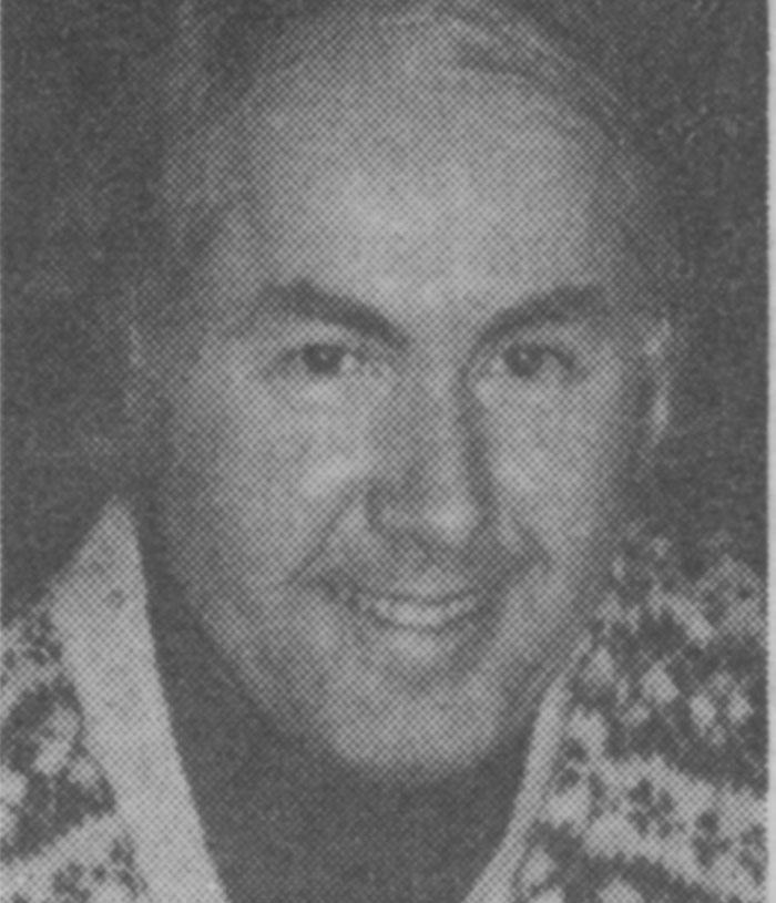 Black and white photo of a smiling man wearing a patterned jacket, illustrating people sharing new facts they learned.