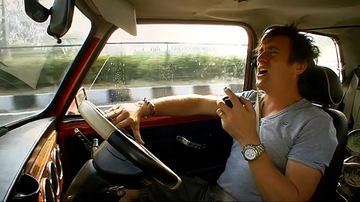 Man sitting in car, sharing new facts with enthusiasm, demonstrating delight and engagement while communicating.